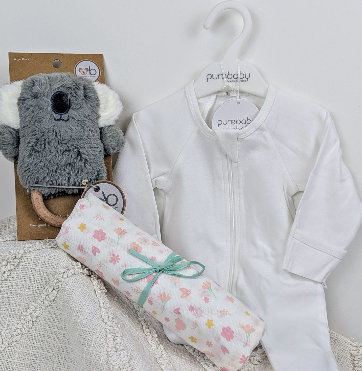 Koala baby rattle toy set with a white baby onesie, floral baby muslin wrap. Baby gift hamper, corporate maternity gift hamper Australia.
